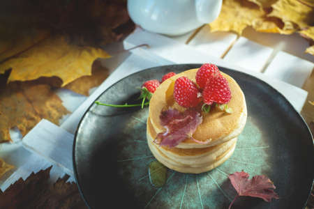 stack of delicious pancakes on a plate with raspberries and syrup.の写真素材