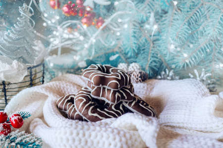 chocolate traditional Christmas cookies and gingerbread. warm composition of a scarf in a spruce decorative frame on the background of a decorated christmas tree.の写真素材