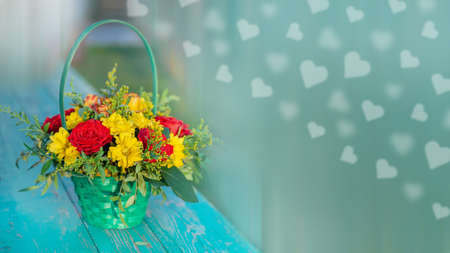 Beautiful roses in a basket on a wooden table, a copy of the space, bokeh in the shape of hearts.の写真素材