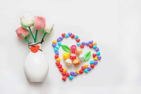 Creative composition of colorful candies and marshmallows on a stick in the shape of a rose on a light background. copy space.の写真素材