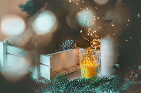 Christmas tree toys and cones with Christmas tree lights and burning candle on rustic wooden background. New Year's still life.の写真素材