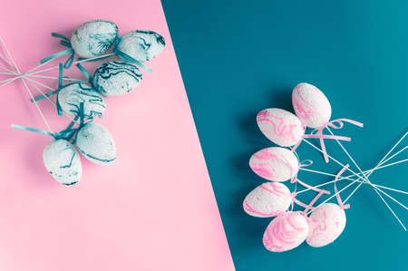 Easter composition. Decorative eggs are laid out on a two-tone pink and blue background. copy space.の写真素材