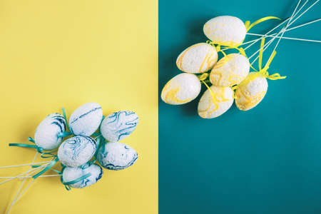 Easter composition. Decorative eggs are laid out on a two-tone yellow-blue background. copy space.