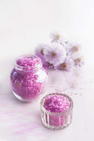 Lavender salt with natural spa products and bath decor on a pink background. Copy space.