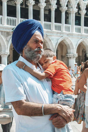 August 25, 2012. Venice, Italy. Portrait of a tourist from India with a child in his arms in St. Mark's Square. Tourists in the center of Venice.のeditorial素材