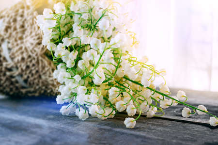 bouquet of lilies of the valley in a basket. Spring still life. flowers of early spring-lilies of the valley. copy space.の写真素材