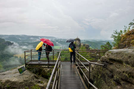 August 11, 2017: Saxon Switzerland, Bastey National Park. people take pictures on the observation deck on a rainy cloudy day. Tourist attractions in Europe. editorialのeditorial素材
