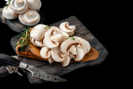natural, organic mushrooms on a vintage wooden table. Sliced Slices Of Fresh Raw Mushrooms Porcini Mushrooms On A Wooden Cutting Board, Isolated On A White Background, Side View.の写真素材