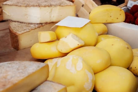 Assortment of craft cheese on the counter of the farmers ' market. The farmer's market presents the products of a small business-a private cheese factory. Italian cheese scamorza is made by Russian cheesemakers.の写真素材