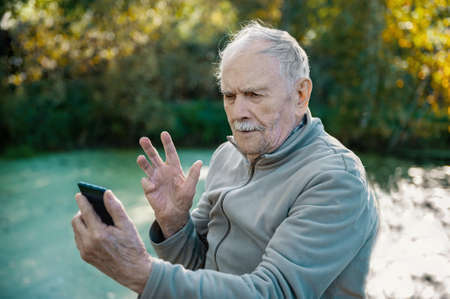 gray-haired, 88-year - old man with glasses happily counts his savings.