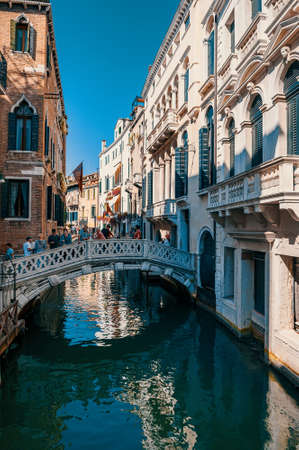 VENICE, ITALY-AUGUST 2021: Venice Canal with tourists standing on the bridge. Beautiful romantic view of the bridges of Veniceのeditorial素材