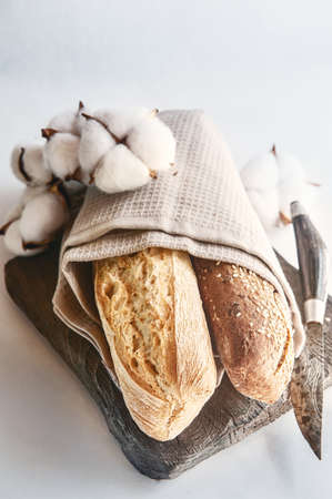 Three types of bread are lying in a napkin on the tableの写真素材