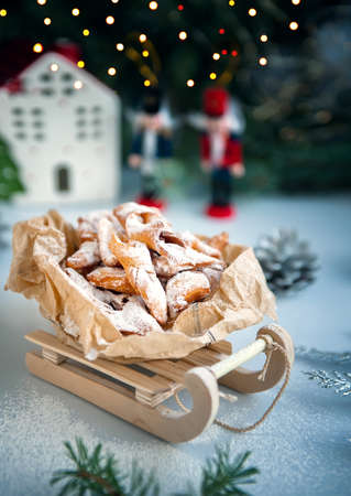 Christmas decoration with antique wooden sleigh. Freshly baked homemade cookies brushwood in the...