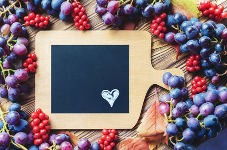 Bright autumn background of grapes and lemongrass with a copy of the space. Top view. heart on a black backgroundの写真素材