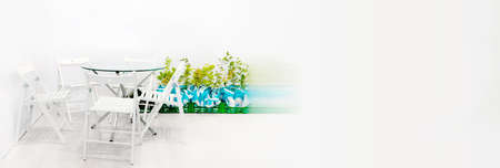 White garden furniture with an installation of green plants. A symbol of outdoor recreation and in...
