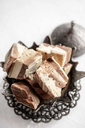plate with halva made of sunflower seeds on a bronze tray, selective focus. Still life with halva in...