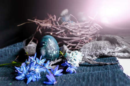 Blue Easter eggs in a nest on the Easter holiday table. A bright glare of light symbolizes a star....