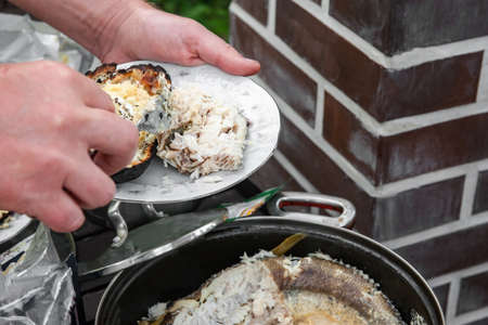 Cooking white fish in cream. Fish stewed in cream is prepared for a picnic in nature.
