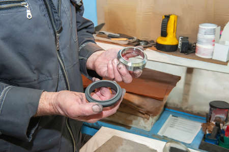 worker uses his hands to make the final polishing of stainless steel parts at a metal products...