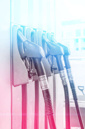 pistols at the gas station. Refueling modern car at gas filling station, close up.
