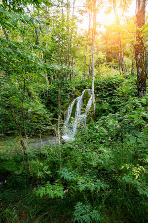 Waterfalls reflected in the lake. The magnificent landscape of the waterfall and lake. Majestic view of the Plitvice Lakes National Park.の写真素材
