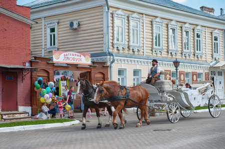 12.06.2022 Kolomna, Moscow region. A horse-drawn team is taking tourists on an excursion. The...