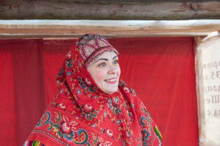 Portrait of a middle-aged woman in a bright red Pavlovsky Posad shawl. A costumed character at Maslenitsa. Kolomna, presentation of the Pastille Museum on Maslenitsa. March 17, 2013のeditorial素材
