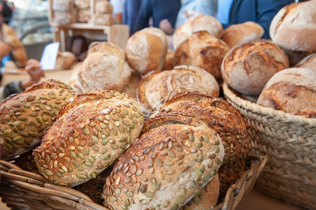 Rye sourdough bread with sunflower seeds on the counter. Bulging round loaves of wholegrain bread from a private bakery. Small businessの写真素材