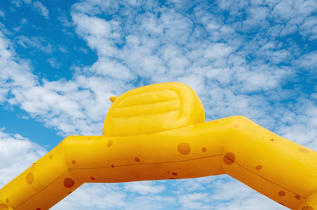 Yellow inflatable advertising banner with no lettering against the skyの写真素材