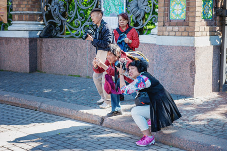June 7, 2015 Saint Petersburg, Russia : Tourists from China take pictures of sights in Saint Petersburg. Chinese tourists view the Church of the Savior on Spilled Blood.のeditorial素材