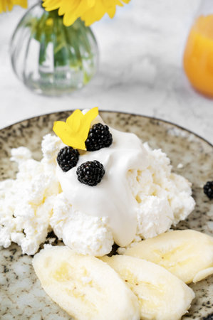 Farm fresh cottage cheese with berries and banana slices. Early breakfast of cottage cheese with...