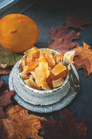 candied and dried pumpkin. Close-up of candied homemade pumpkin fruits from a natural farm, sprinkled with powdered sugar.の写真素材