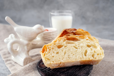 Craftsman sliced toast bread with butter on a wooden cutting board and milk. Simple breakfast on a...