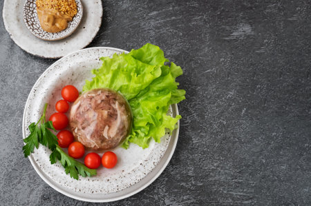 Homemade jellied meat with mustard and horseradish on the table. Aspic. Homemade jelly with mustard, tomatoes and garlic on the table. Kholodets, traditional Russian food.の写真素材