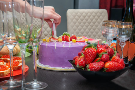 festive table with a bowl of strawberries and a big pink cake. Birthday, holiday, New Year.の写真素材