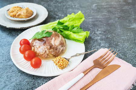 Homemade jellied meat with mustard and horseradish on the table. Aspic. Homemade jelly with mustard, tomatoes and garlic on the table. Kholodets, traditional Russian food. Copy space.の写真素材