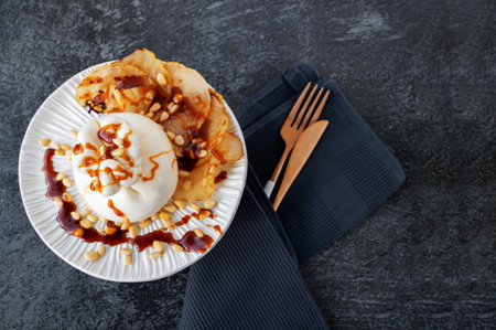 burrata is served with roasted caramelized pear and pine nuts. Top view, flat lay. Copy space.の写真素材