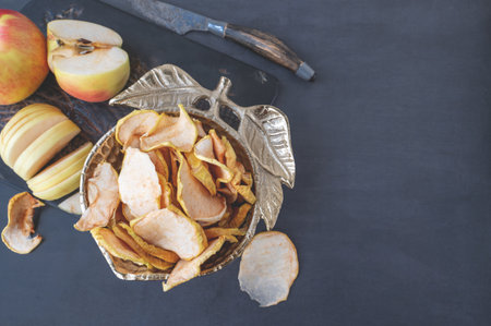 Dried apple chips in a bowl. Dehydrated apples. Homemade dried organic apple slices. Top view, flat lay, close-up. Copy spaceの写真素材
