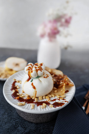 Italian burrata cheese. Burrata served with marinated pear, pine nuts and caramel sauce. Cafe menu.