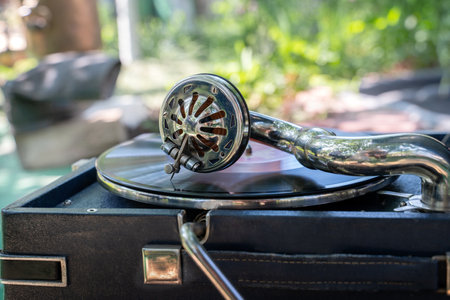 Vintage old record player gramophone needle on vinyl record. Round shiny metal needle holder head reproducing music. Retro vintage vinyl player. Needle old gramophone close up.の写真素材
