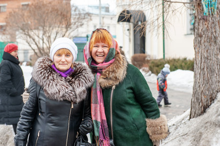 Kolomna, Moscow region, Russia, February 22, 2015. The celebration of Maslenitsa at the temple. Two middle-aged friends are enjoying the holiday. The women smile happilyのeditorial素材