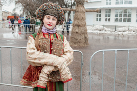 Kolomna, Moscow region, Russia March 10, 2019: Russian national clothing. A beautiful girl in a Russian national retro costume. People celebrate Maslenitsa. Maslenitsa is a Russian holiday. People eat pancakes, play folk games, have fun in winterのeditorial素材