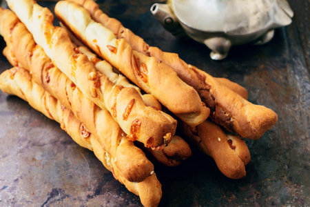 handmade grissini. Italian grissini or salted breadsticks with parmesan and onions on a light stone...