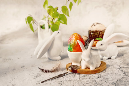 Spring still life with a painted egg. Easter bunnies, chocolate cupcake and eggs with a delicate...