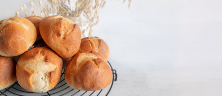homemade buns. Homemade buns on a wooden board with wheat ears. Homemade buns for dinner, boiled with vegetable milk. Copy space. bannerの写真素材
