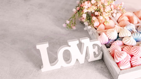 box of colorful small handmade meringue on the table. handmade meringue flowers prepared for gift giving. Sweet romantic gift. Word of Love.の写真素材