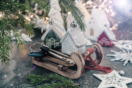 Sledding with toy houses and keys. Concept of new housing in the new year, new year - new housing.