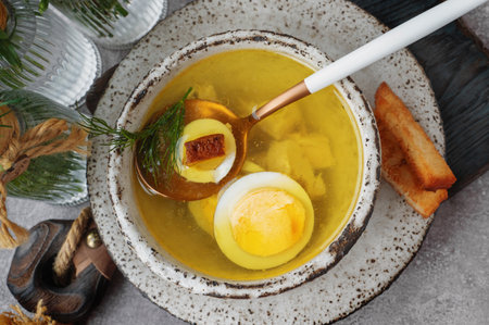 chicken broth with egg. Chicken soup with pieces of boiled fillet and halves of a quail egg. The...