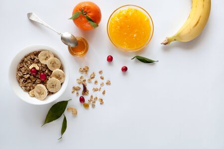 Breakfast with muesli, banana, orange and jam, top viewの写真素材