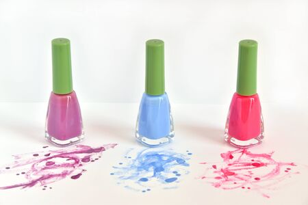 Three similar bottles of different nail polish on white background.の写真素材